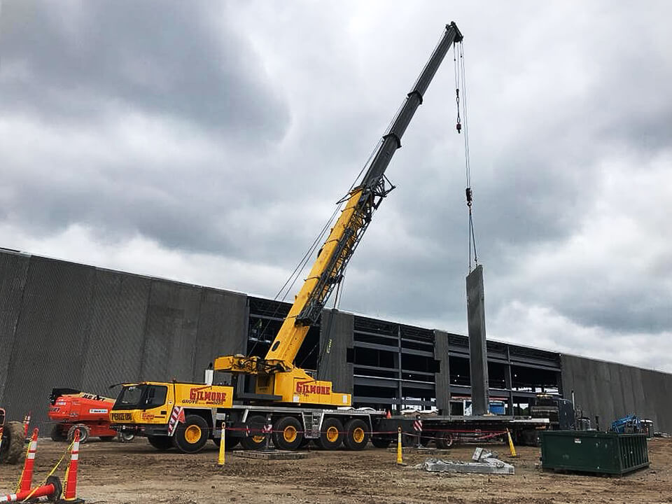 Photo of crane lifting wall of building