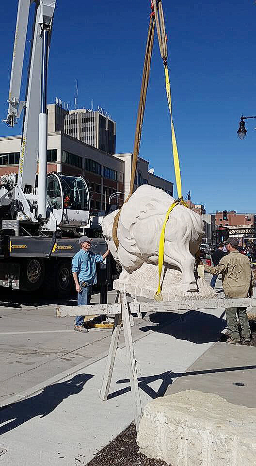Photo of crane lifting bison statue