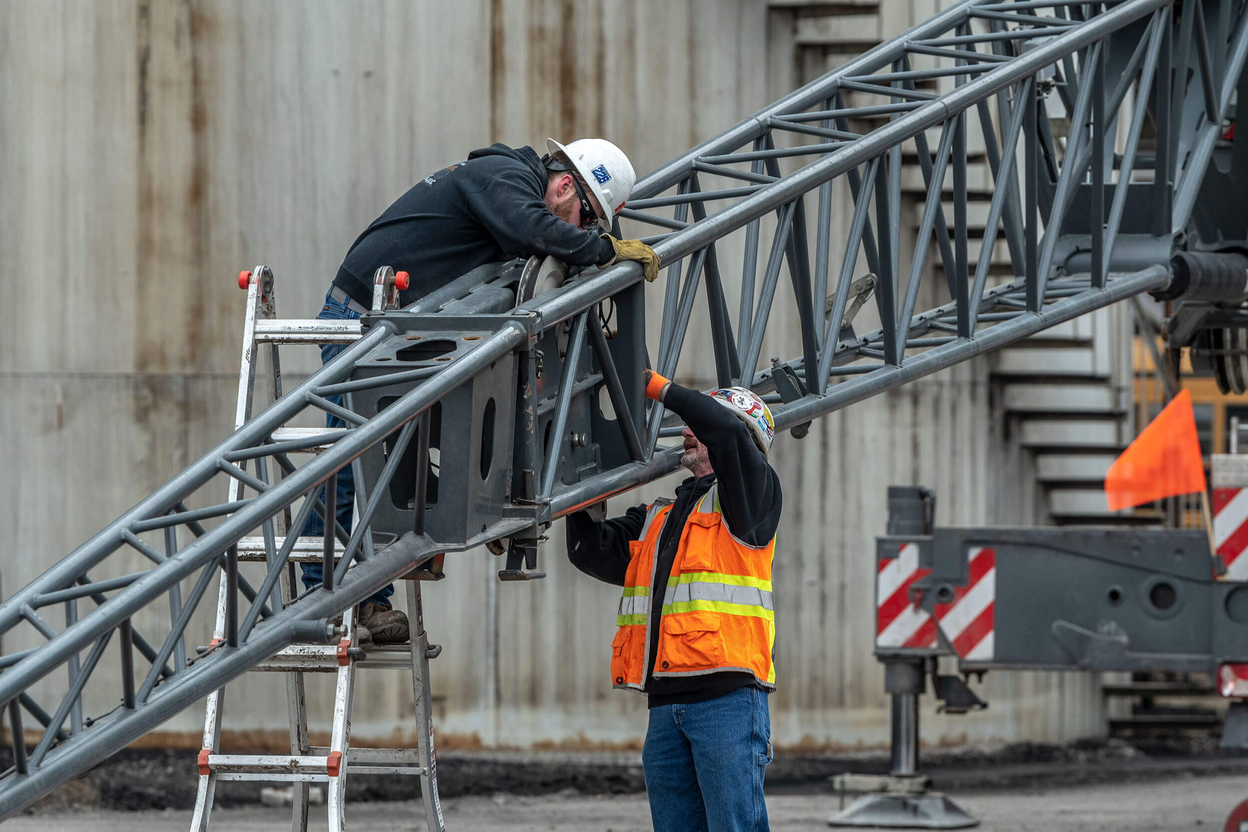 Photo of two workers making adjustments on a boom